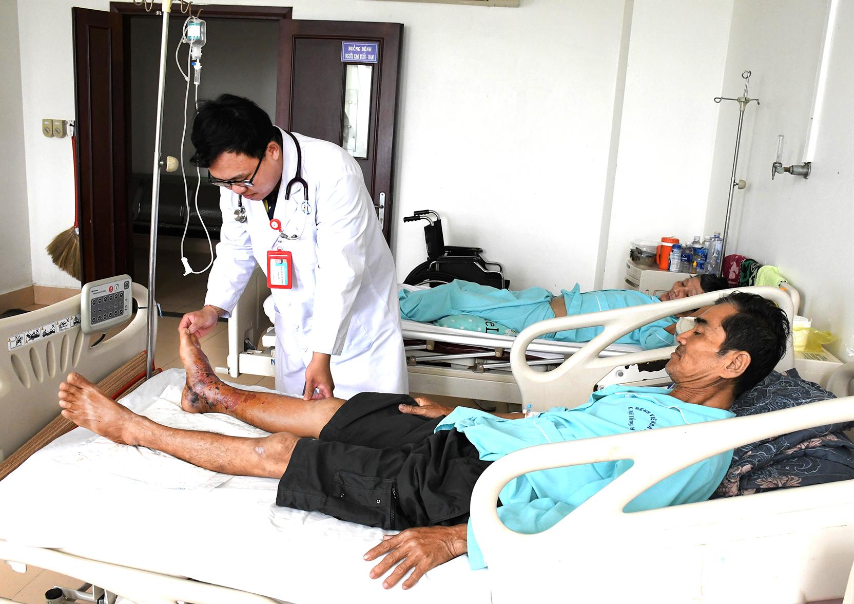 Bác sĩ Nguyễn Tấn Phát, Khoa Hồi sức tích cực - Chống độc (Bệnh viện Bà Rịa) kiểm tra lại vị trí bị rắn cắn cho người bệnh.